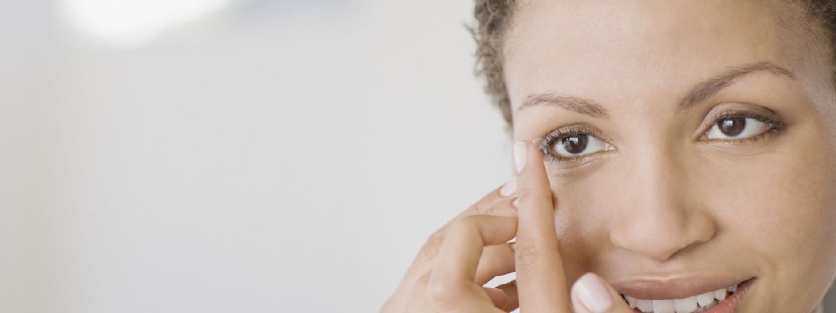woman putiing in her contact lens
